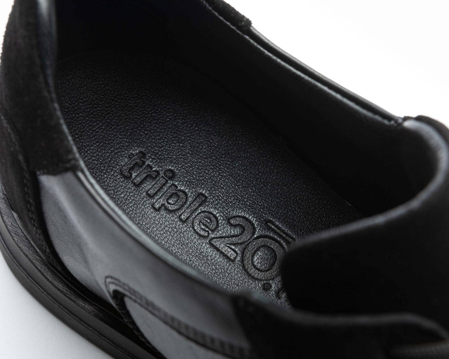 Detailaufnahme der schwarzen, gepolsterten Leder-Decksohle eines hochwertigen triple20 Dartschuhs. Das Logo ist sehr sorgfältig eingeprägt und man kann die Hochwertigkeit deutlich erkennen. Die Decksohle und das Futter wirken sehr bequem.