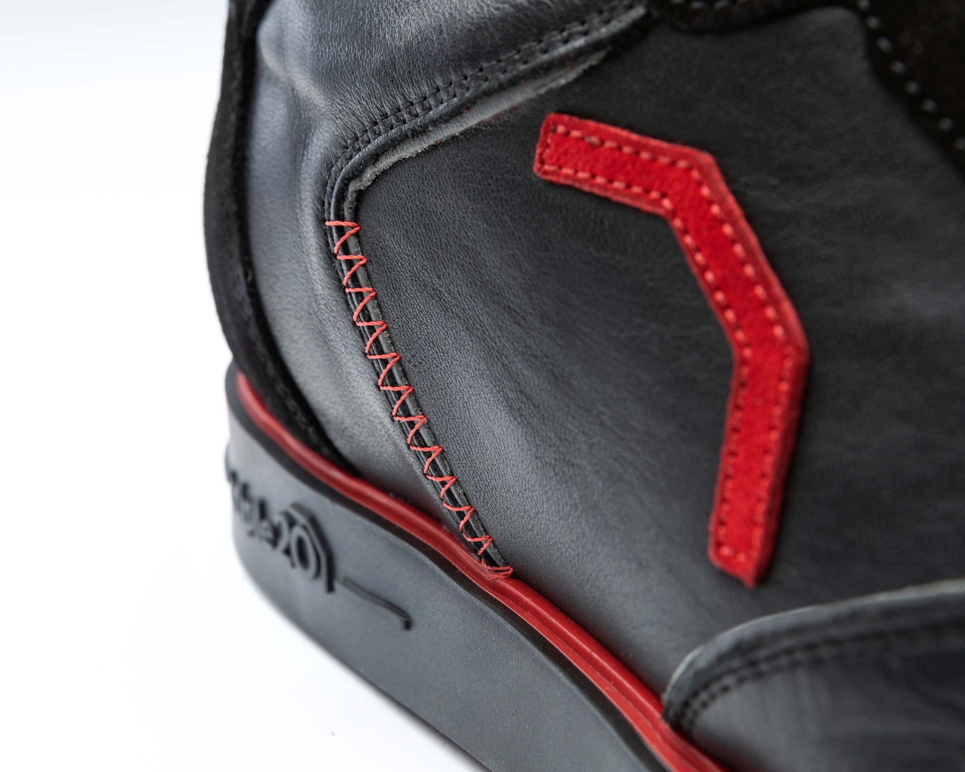 Detailfoto des feurig roten Emblems aus Leder, welches auf einem schwarzen Vollleder-Dartschuh von triple20 angebracht ist. Der deutsche Hersteller legt nicht nicht nur Wert auf Funktion, sondern auch auf modisches Design.