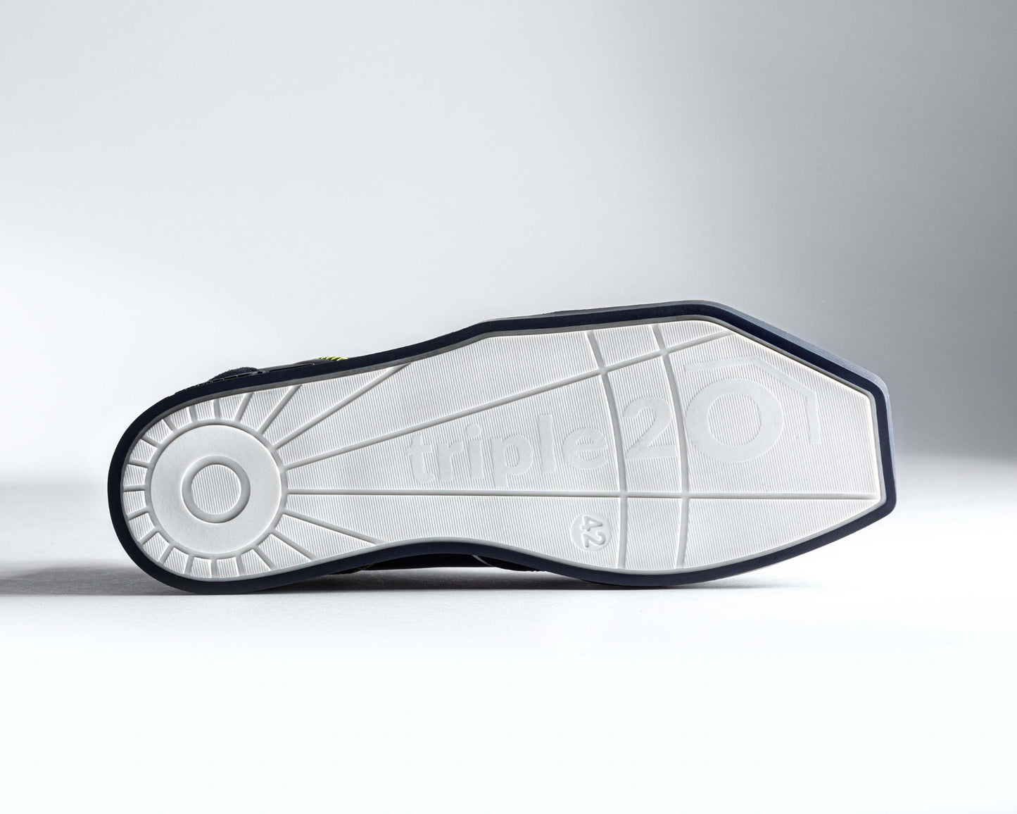 Bild einer weißen triple20 Dartschuh-Laufsohle von unten, also der Lauffläche. Erkennbar ist das spezielle, eckige Sohlendesign sowie das besonders schön gemachte Dessin der Profilierung.