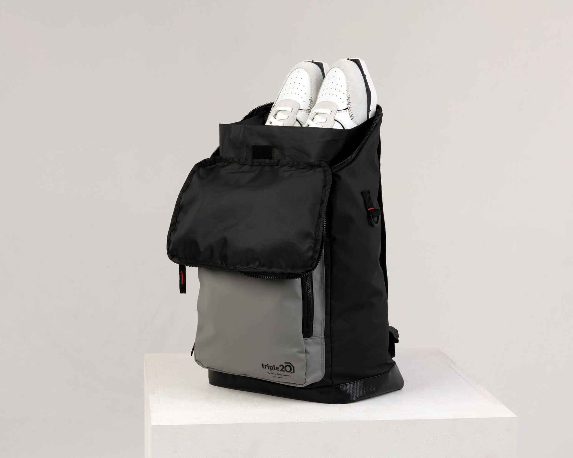 Produktfoto eines Rucksacks, der speziell für den Dartsport entworfen wurde. Man sieht, dass aus der Öffnung ein Paar Dartschuhe ragt, dieses kann in einer eigens entwickelten Innentasche so bestens aufbewahrt und getragen werden.